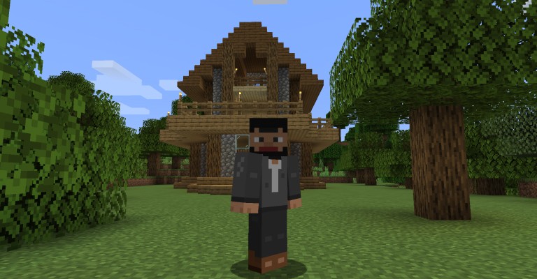 A Minecraft character standing in a grassy clearing in front of a two-storey wooden house with a balcony and lanterns, oak trees on either side.